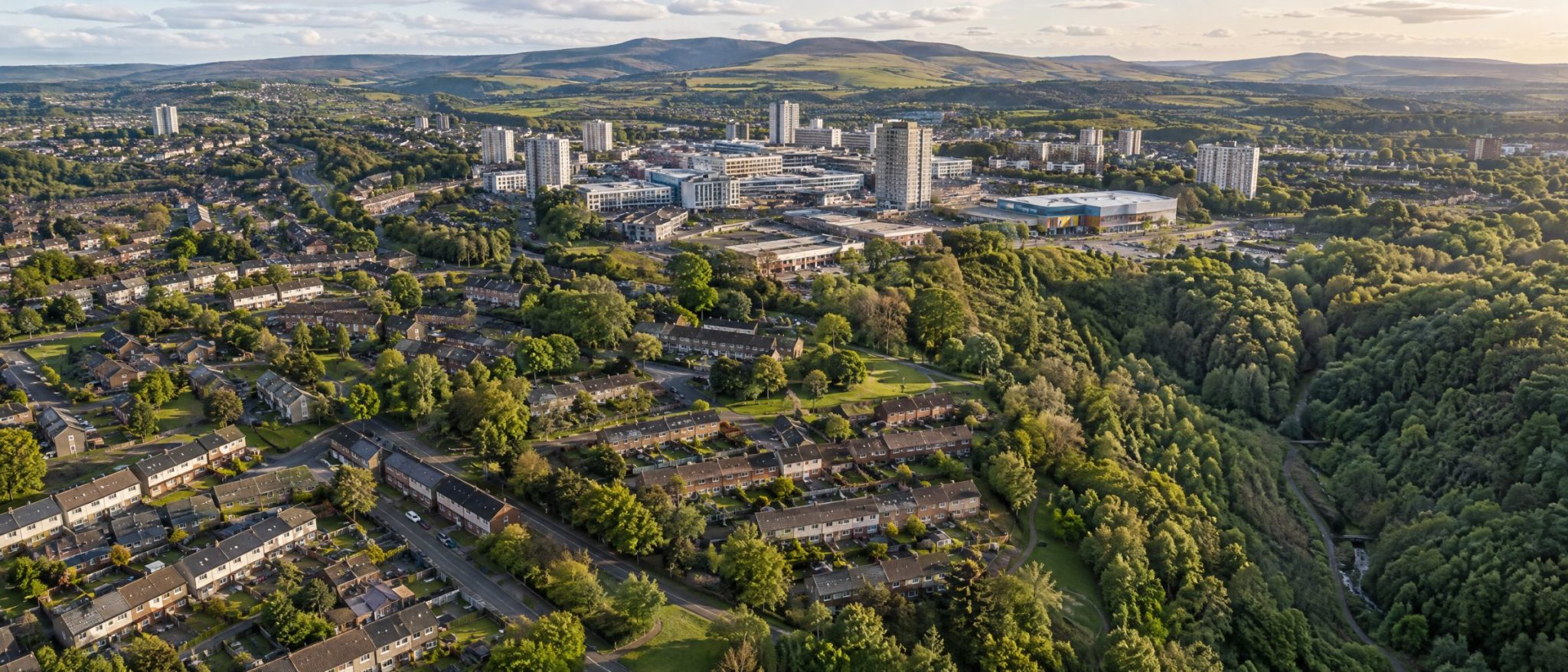 Aerial view of Cumbernauld with its hilltop town centre, homes and wooded glen