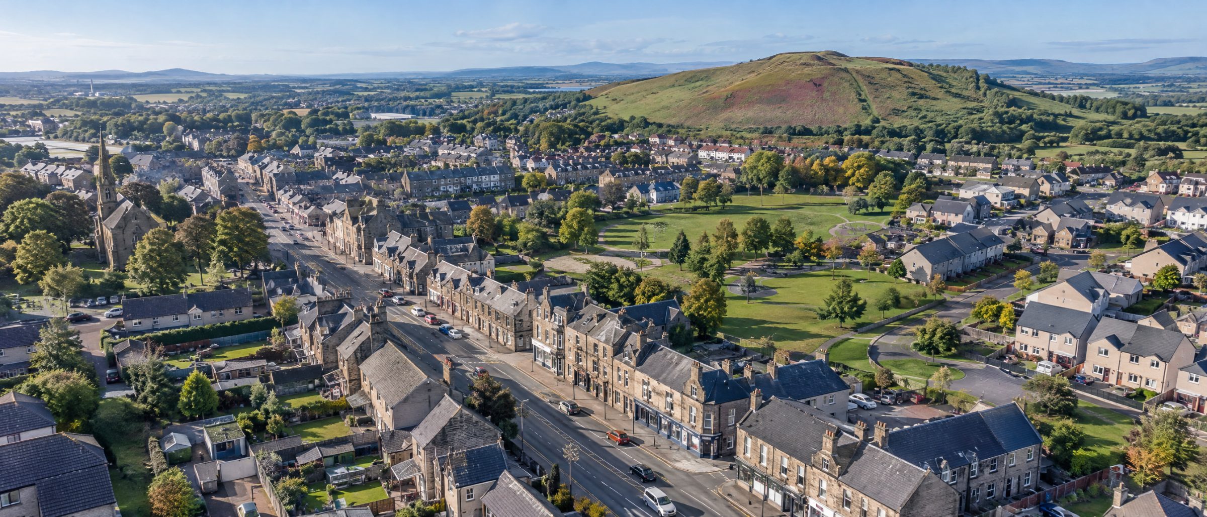 Aerial view of Broxburn with its main street, terraced houses and new build homes