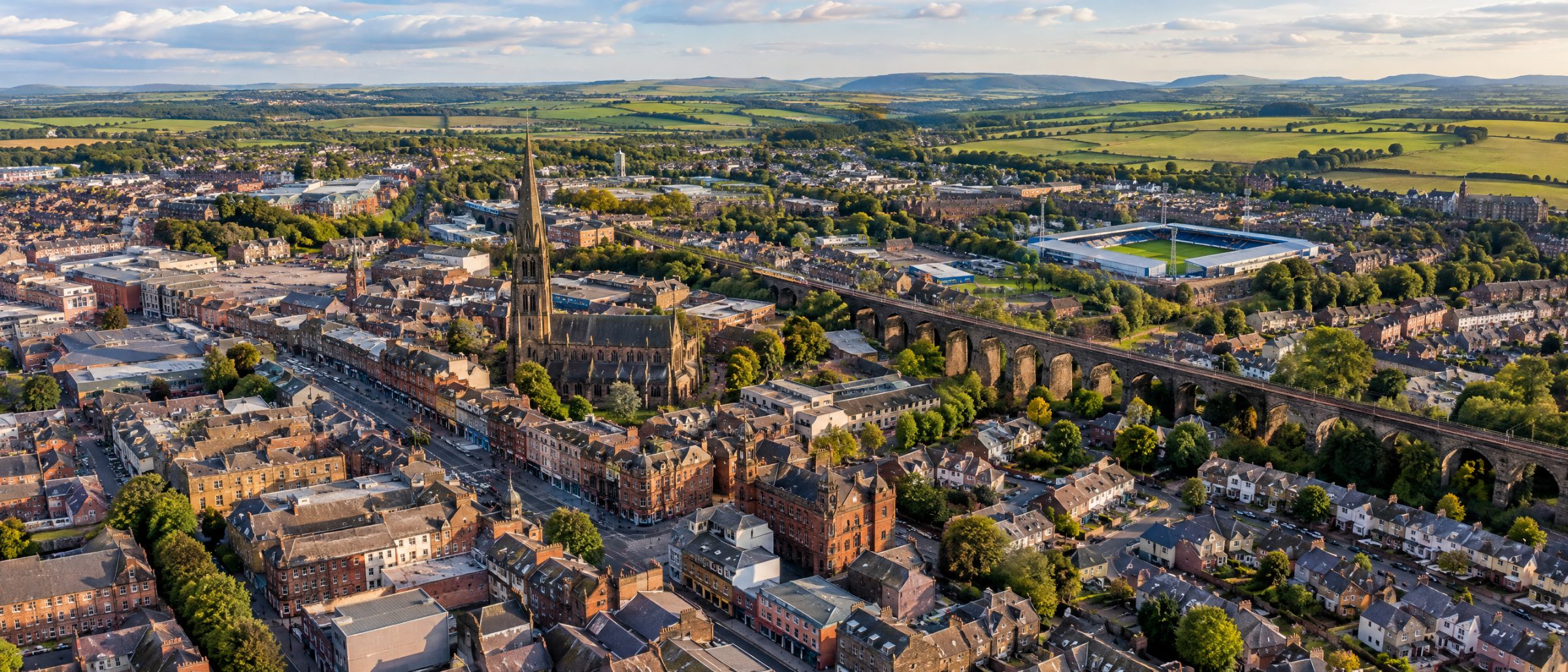 Aerial view of Kilmarnock with its town centre, church spire, railway viaduct and homes