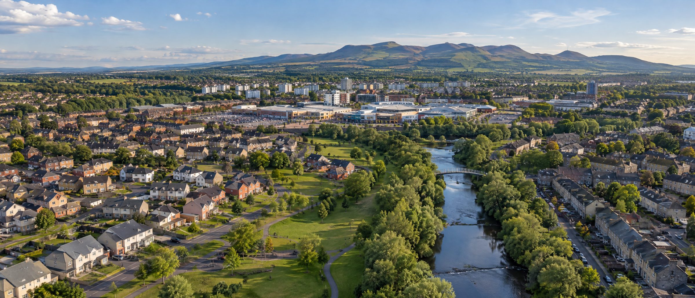Aerial view of Livingston with family homes, parkland and the River Almond, and the Pentland Hills beyond