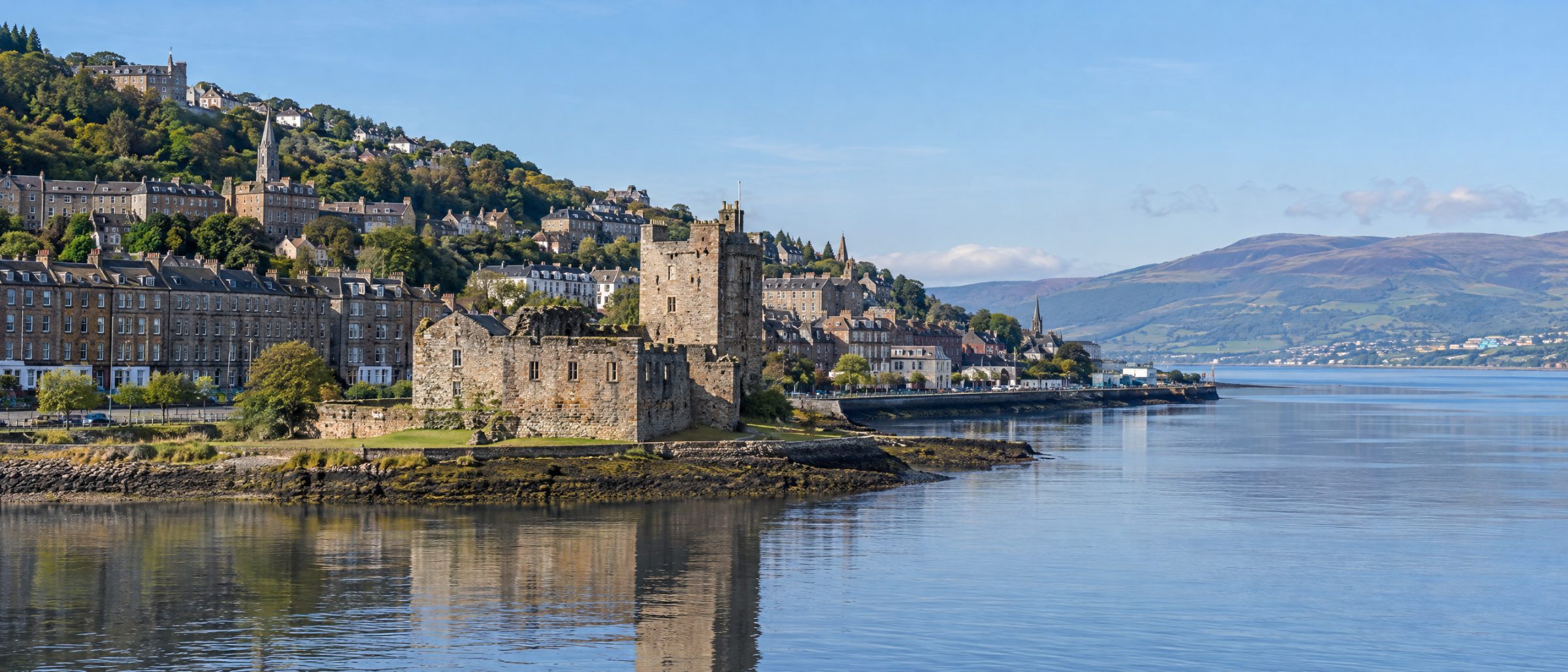 Newark Castle on the River Clyde at Port Glasgow, with tenements and homes on the hillside behind